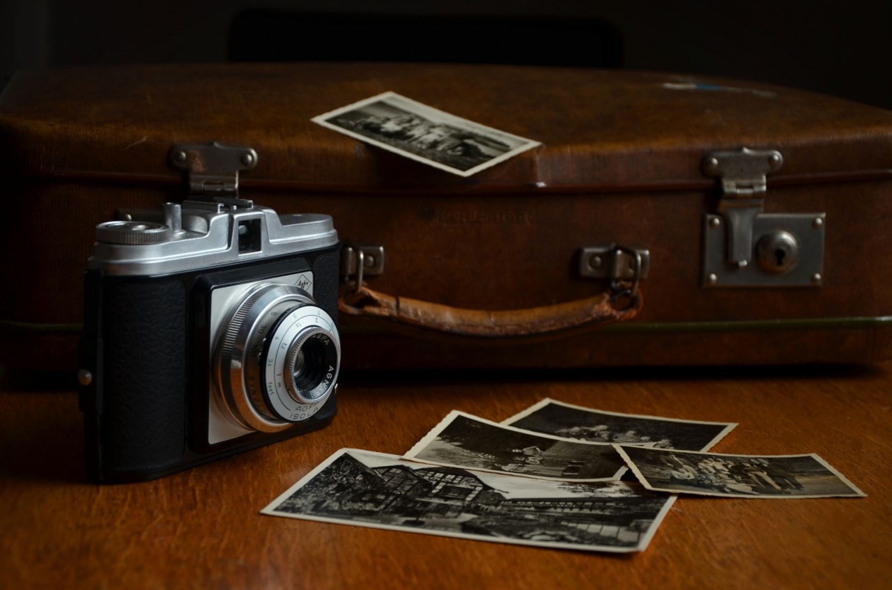 old-vintage-polaroid-camera-with-photos-and-a-bag